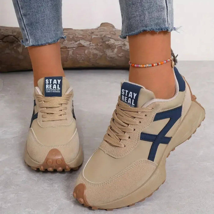 Beige lace-up trainers with blue side panels and chunky rubber sole, 'STAY REAL' tab