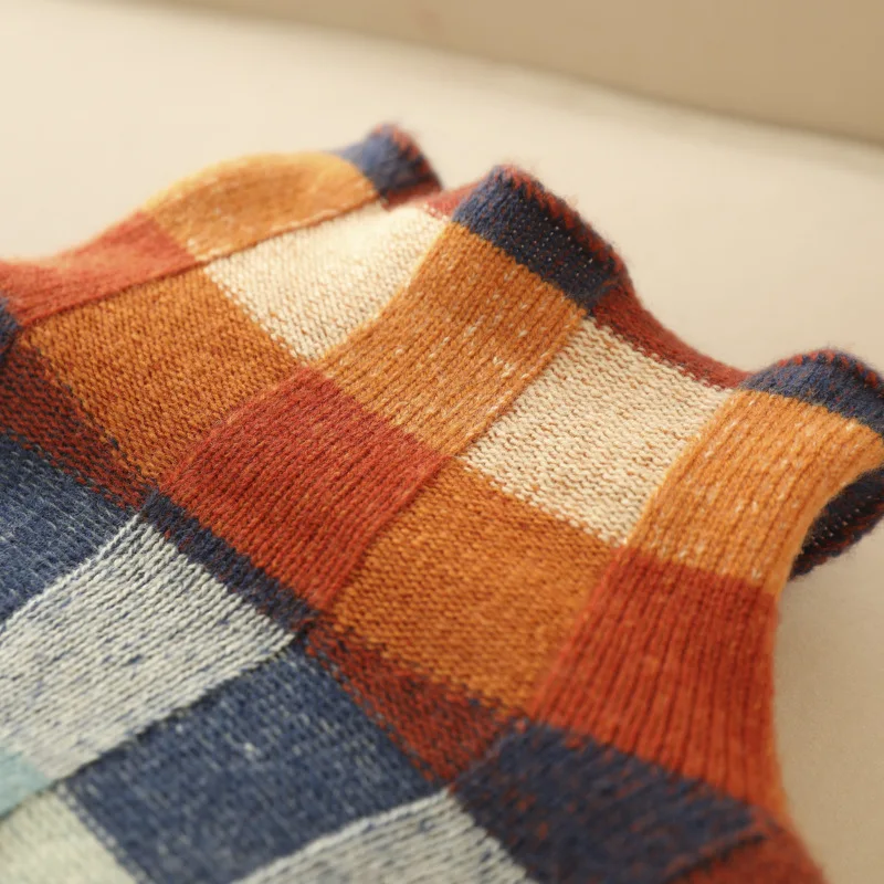 Multicolor checkered knit squares on sweater with textured stitch details