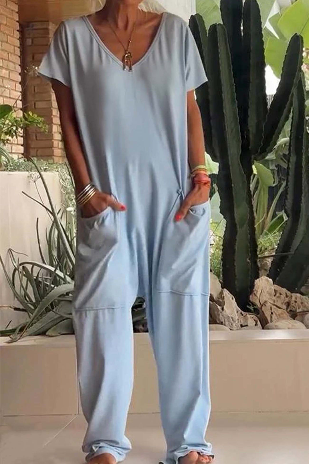 Light blue relaxed pocket jumpsuit with V-neck, short sleeves, and wide leg openings