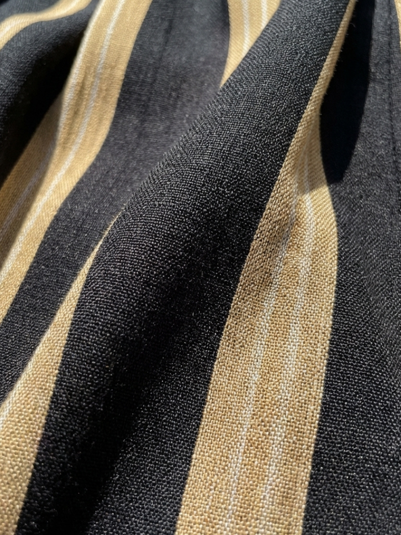 Striped woven fabric close-up with black and gold vertical bands.