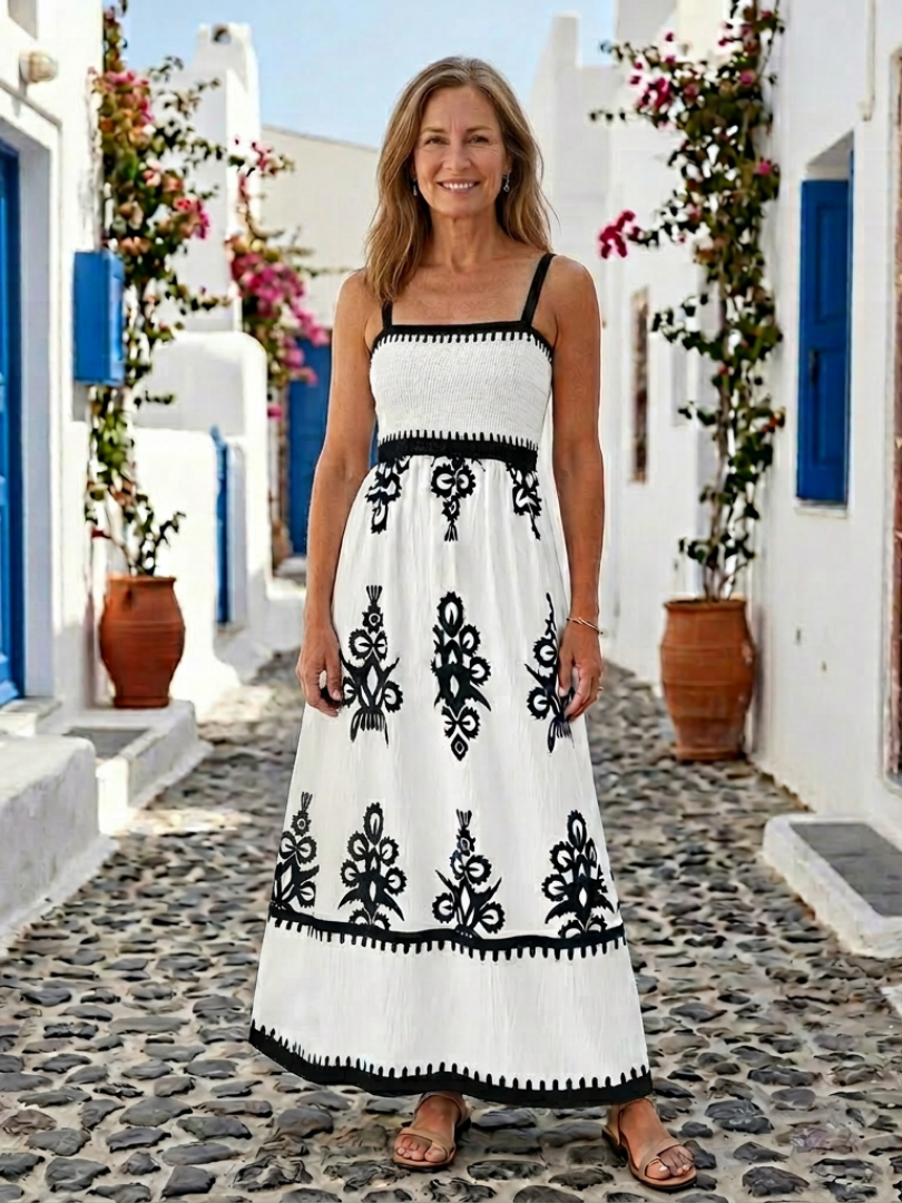 Sleeveless smocked bodice maxi dress with white fabric and black floral design