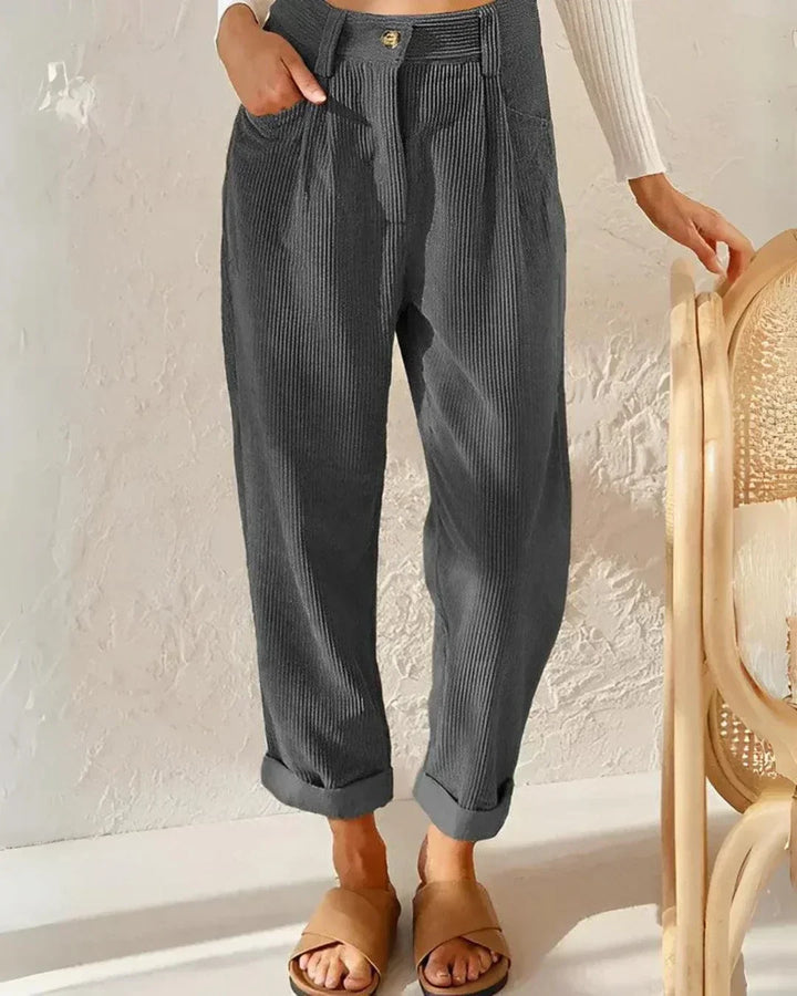 Relaxed corduroy pants in gray with button front, side pockets, and cuffed ankle hem