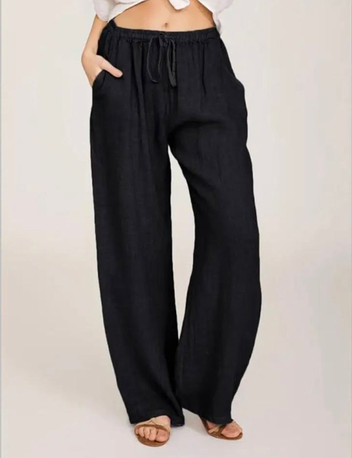Black drawstring pants with elastic waistband and relaxed wide legs.