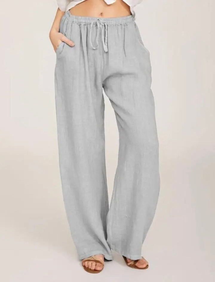 Light gray drawstring pants with elastic waistband and relaxed wide legs.