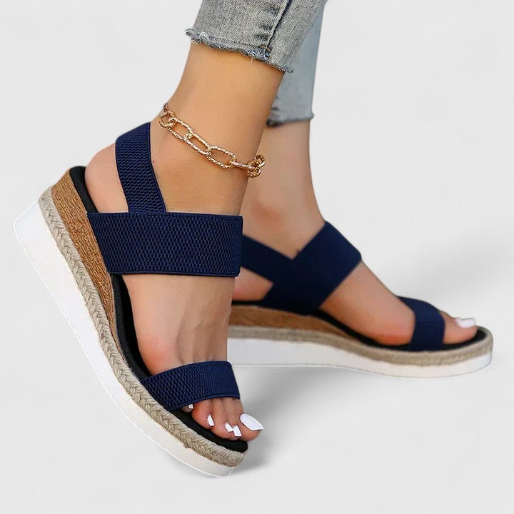 Women’s orthopedic sandals with arch support, navy straps and gold ankle chain, side view.