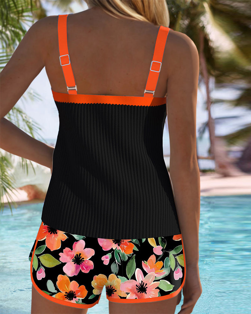 Black tankini set back view with orange trim straps and floral shorts
