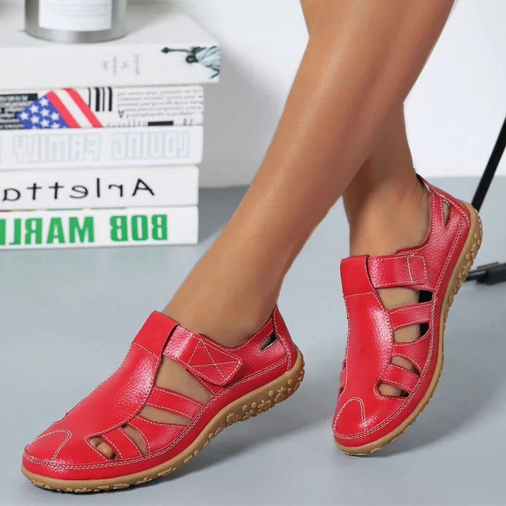 Orthopedic anti-slip sandals on feet, red open toe with hook-and-loop straps