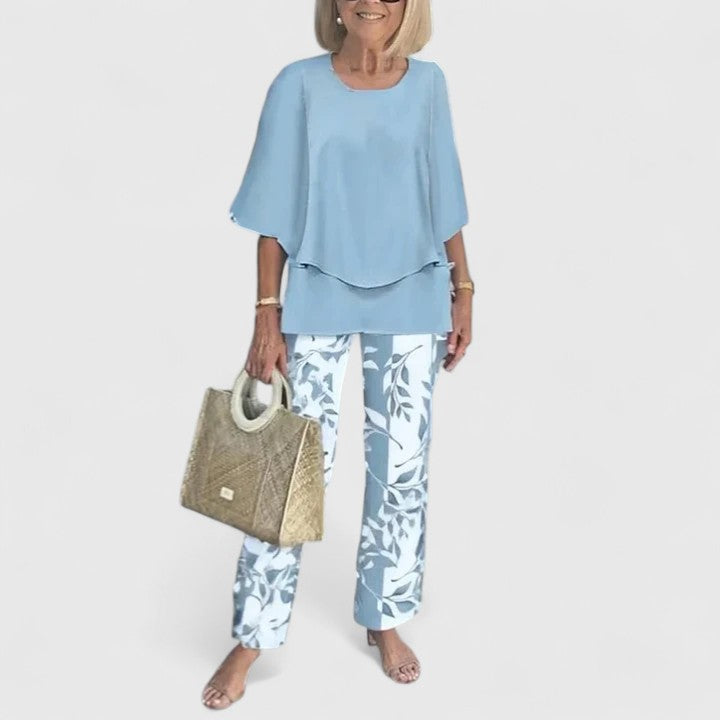 Two-piece blouse and trouser set with blue blouse and white leaf-print trousers