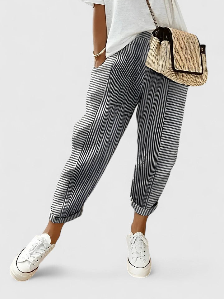 Black striped relaxed pants with elastic cuffs and tapered, pleated legs.