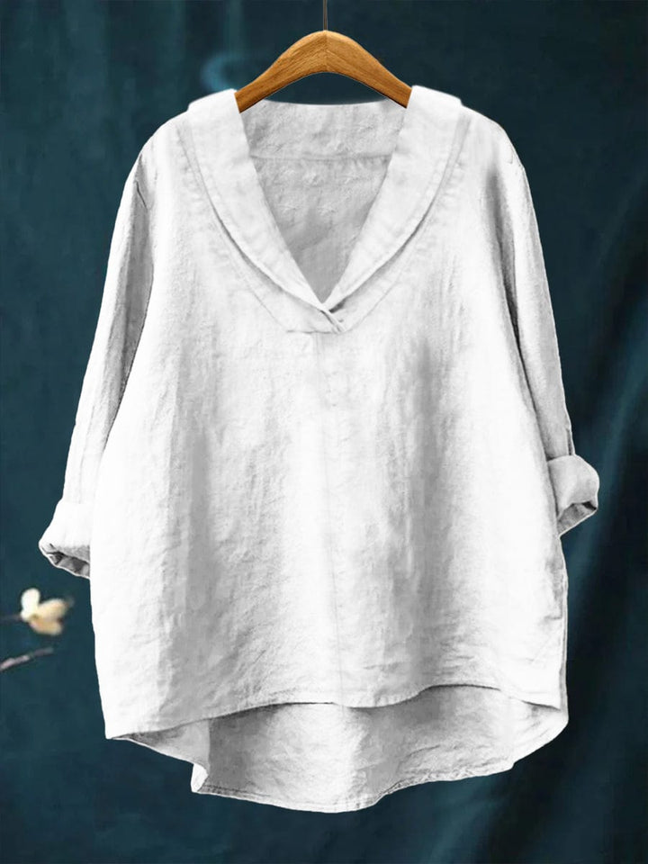 White relaxed linen blouse with V-neck and loose fit, long sleeves, draped hem.