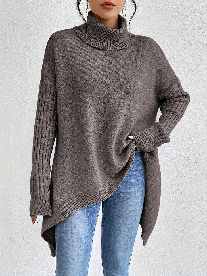 Dark gray oversized turtleneck sweater, asymmetrical drape at hem, ribbed sleeves.