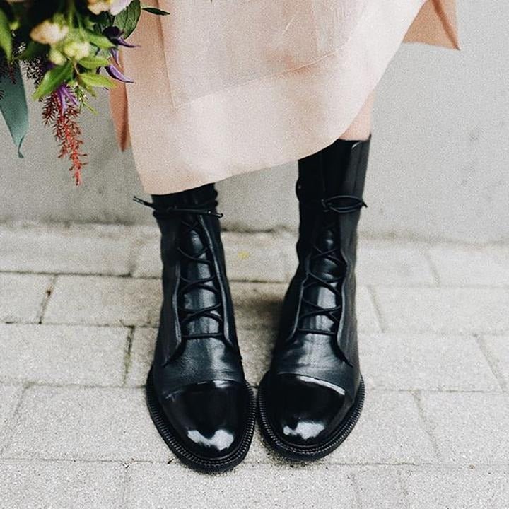 Black lace-up ankle boots with rounded toe, lace-up front, and textured edge sole.