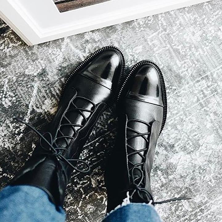 Black lace-up ankle boots, angled view showing side panel seams and laces.