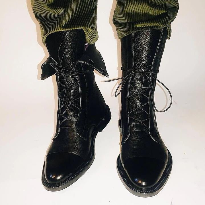Black lace-up ankle boots with glossy leather-look finish, rounded toe, and thick sole.
