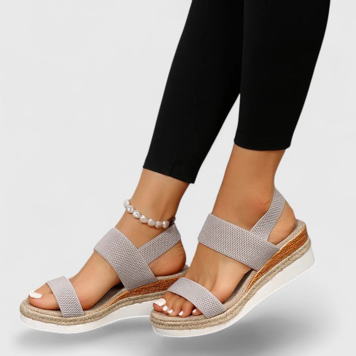 Women’s orthopedic sandals with arch support, light grey woven straps and pearl ankle bracelet.