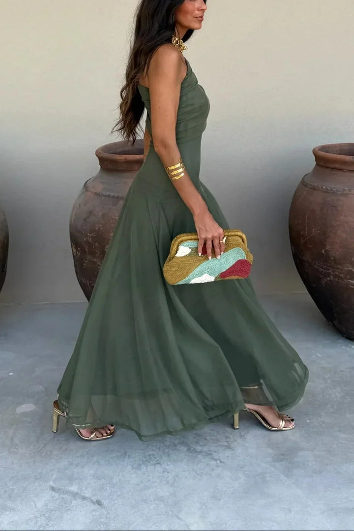 Dark green one-shoulder pleated maxi dress, sleeveless side view with flowing hem
