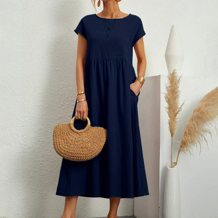 Navy midi dress with short sleeves, round neck, and gathered waist with a flowy skirt.