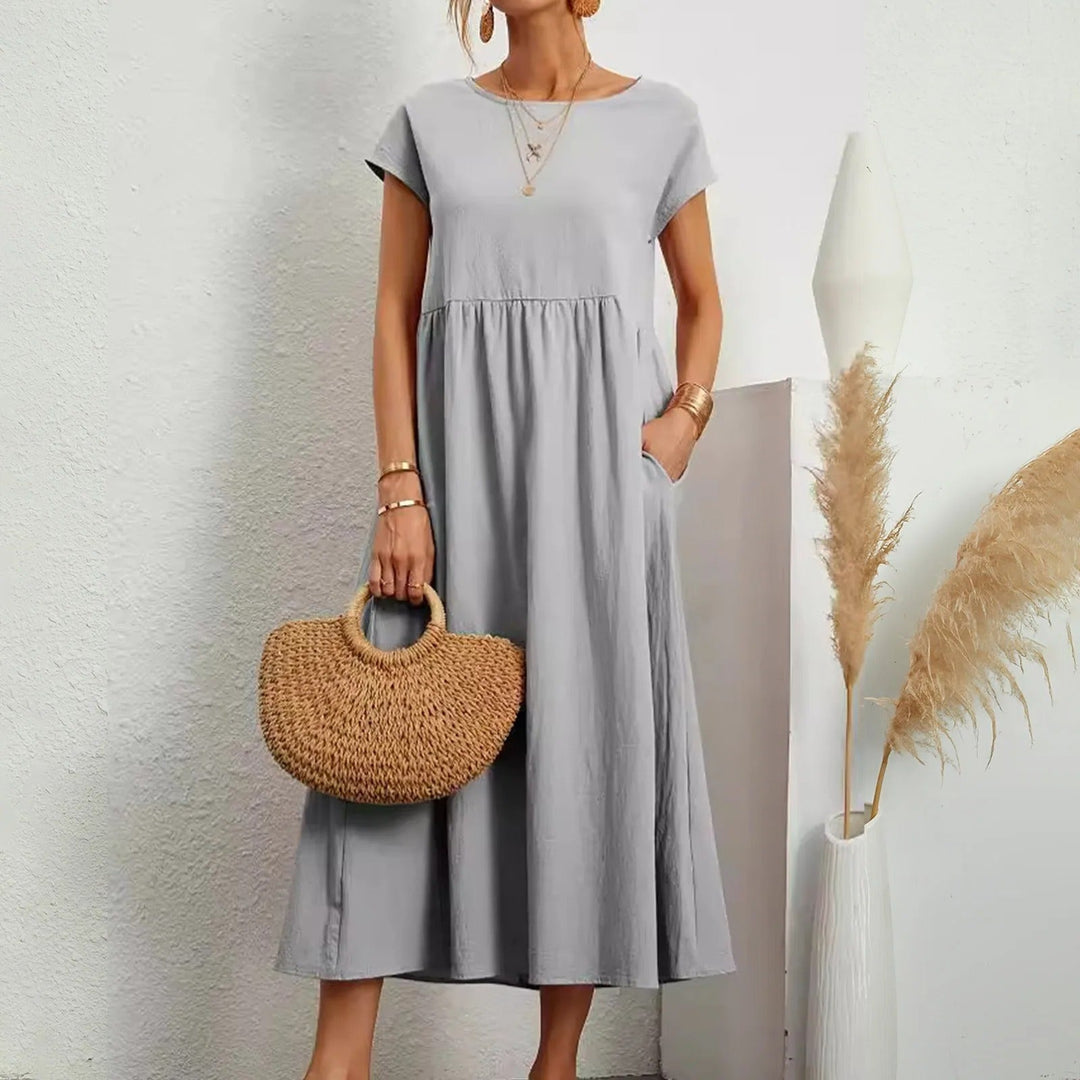 Light gray midi dress with short sleeves, round neck, and gathered waist with a flowy skirt.
