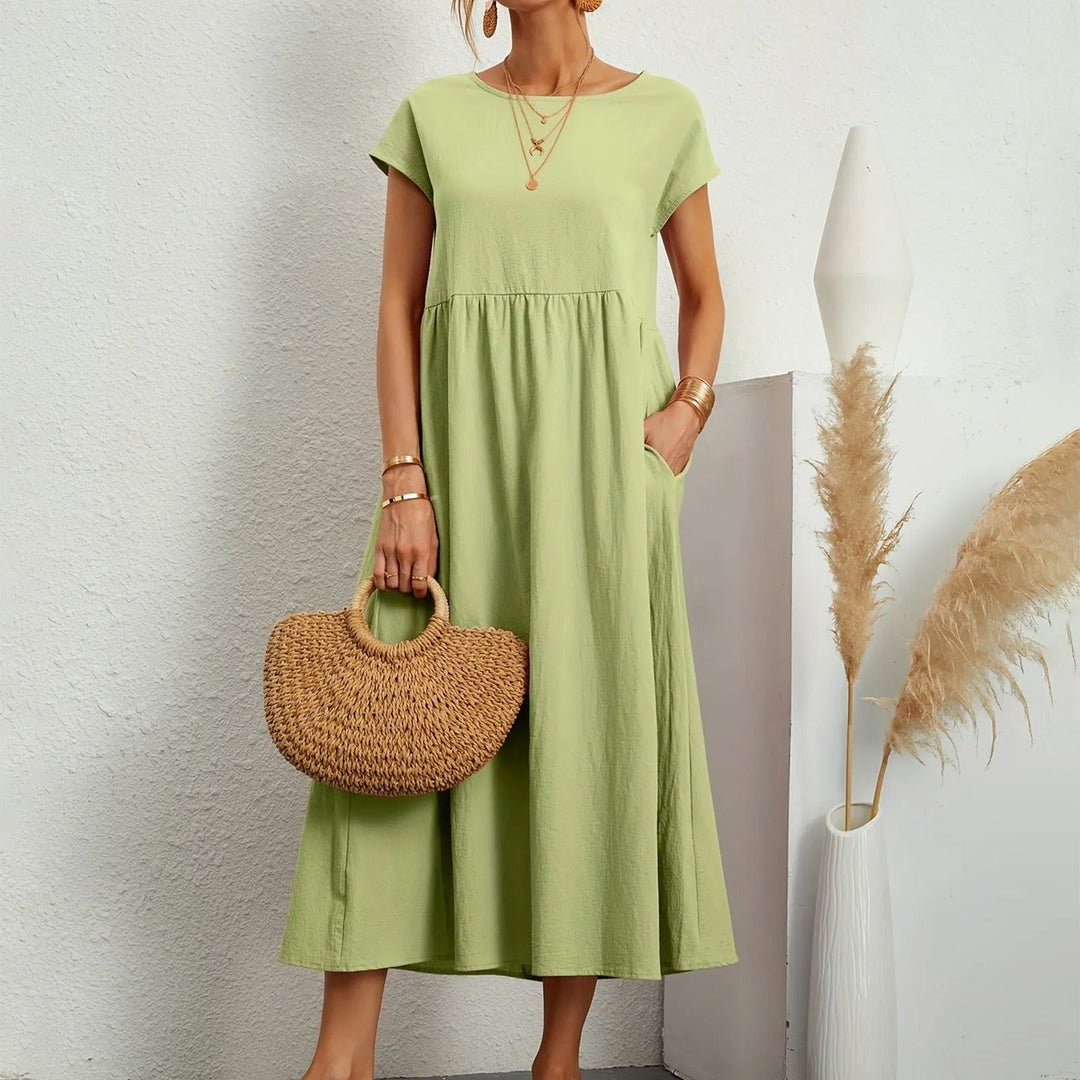 Light green midi dress with short sleeves, round neck, and gathered waist with a flowy skirt.