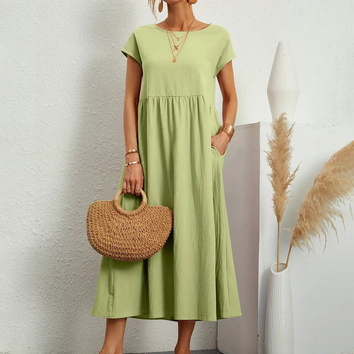 Light green midi dress with short sleeves, round neck, and gathered waist with a flowy skirt.