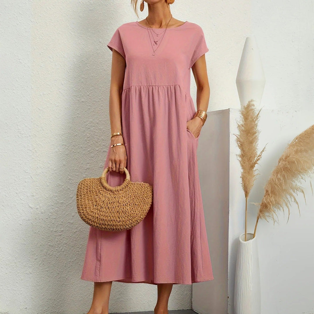 Pink midi dress with short sleeves, round neck, and gathered waist with a flowy skirt.