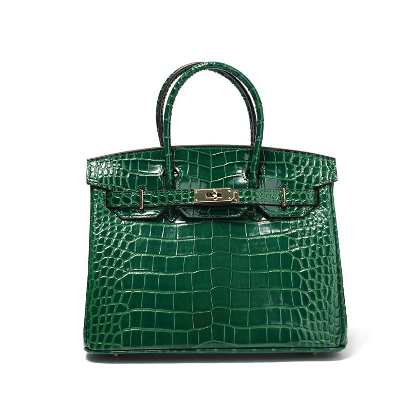 Green croc-embossed structured handbag with top handle and gold clasp.