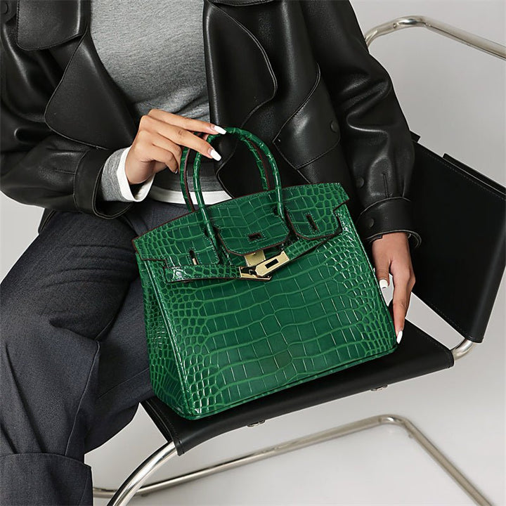 Green crocodile-texture handbag with front gold clasp and carry handle