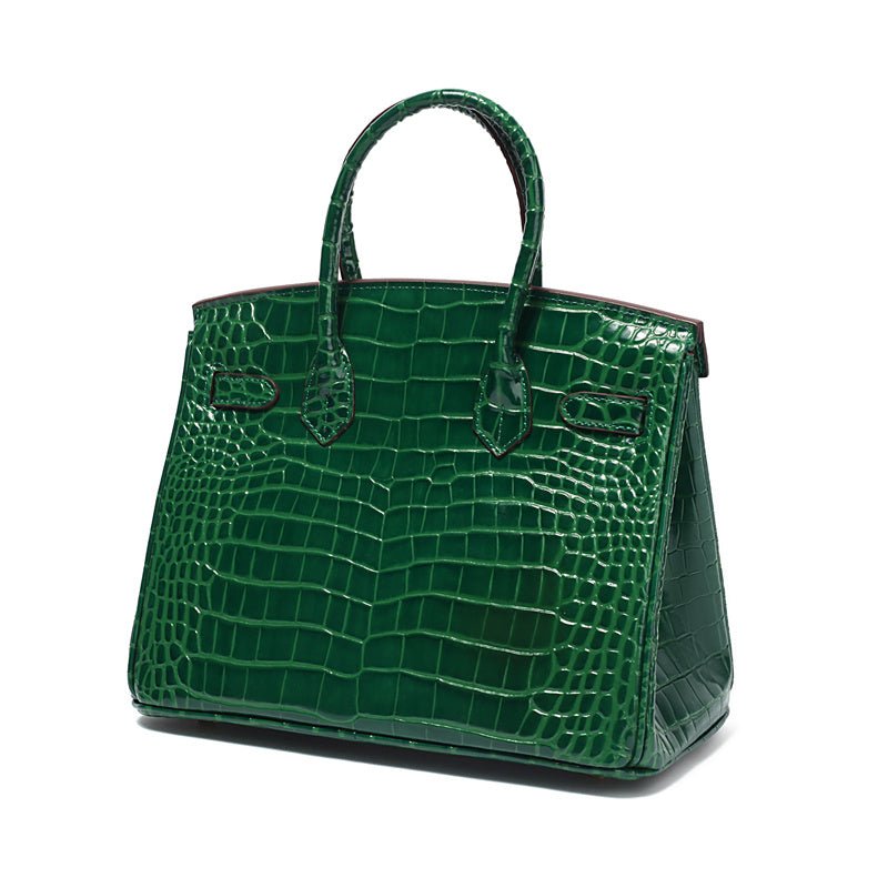 Green croc-embossed top-handle handbag with front latch and side pockets.