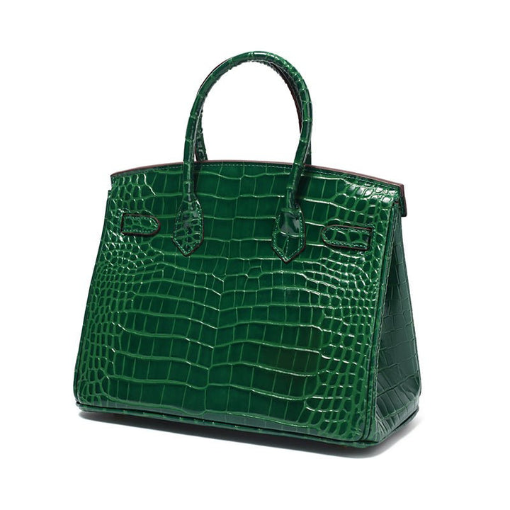 Green croc-embossed top-handle handbag with front latch and side pockets.