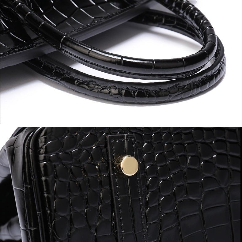 Black crocodile-textured handbag handle and front detail with gold-toned hardware