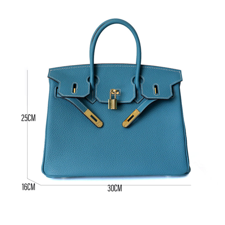 Blue structured handbag with top handles, front flap, and gold-tone clasp hardware