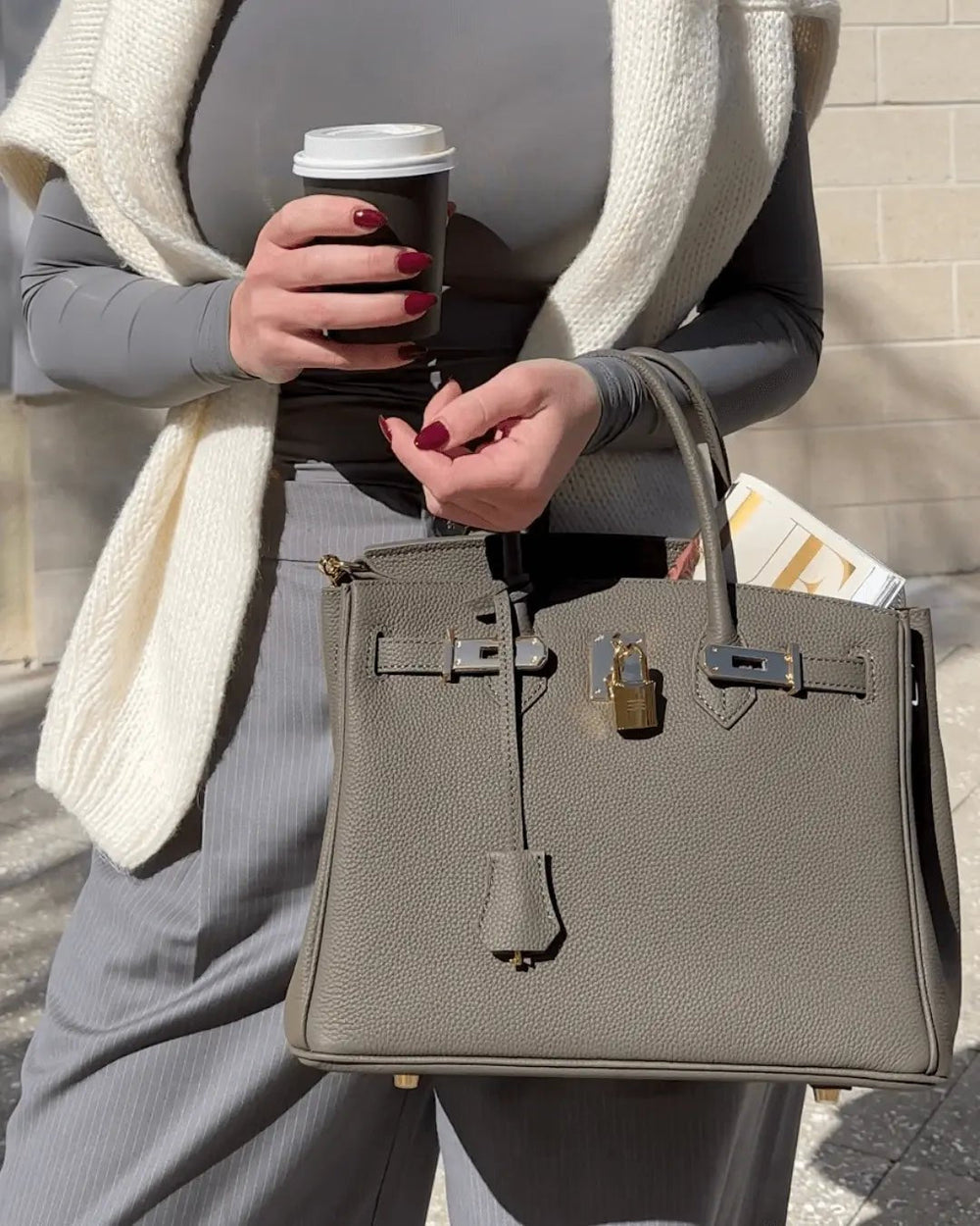 Grey textured handbag with top handle and gold lock clasp