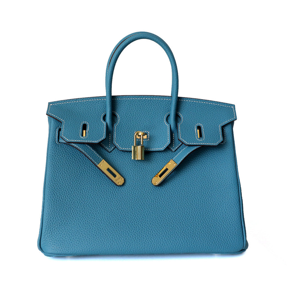 Blue leather handbag with top handles, front lock clasp detail, and gold hardware.