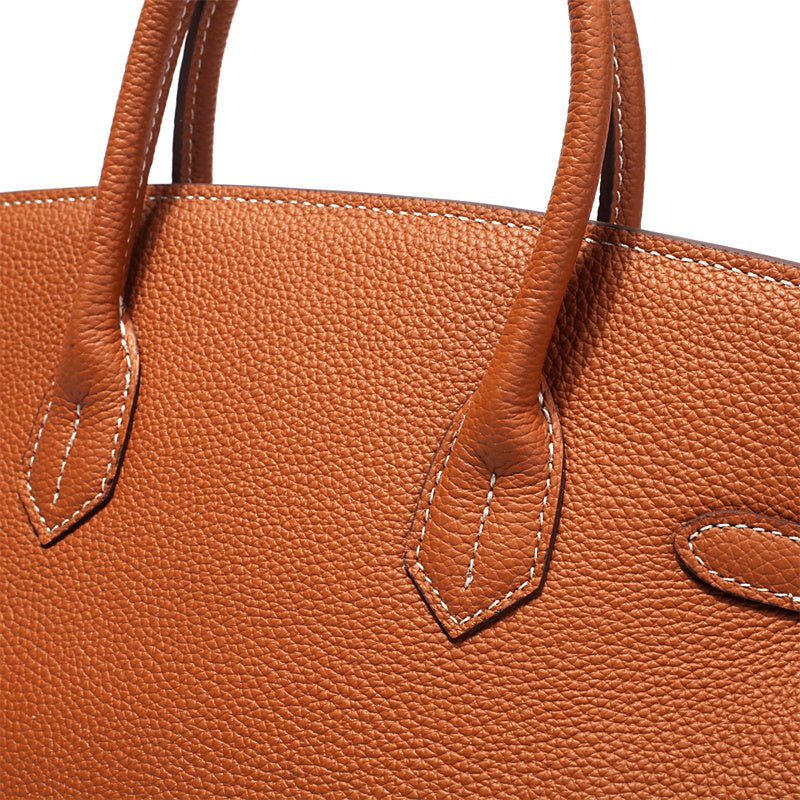 Structured leather handbag with top handles and front stitched panels, orange-brown color.
