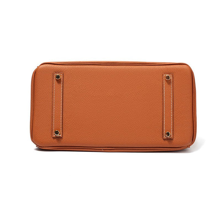 Women’s tan handbag with smooth back panel and metal eyelet details