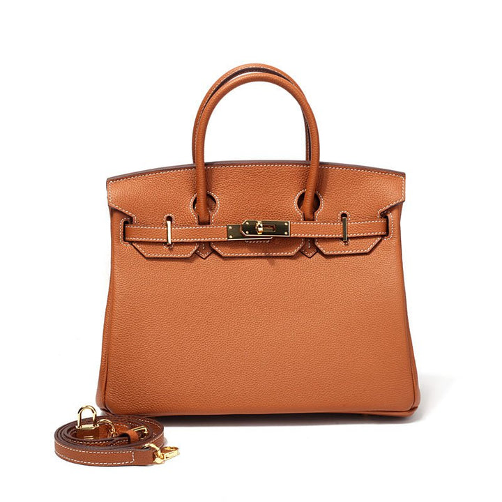 Women’s structured handbag in tan with top handles, front lock, and long strap