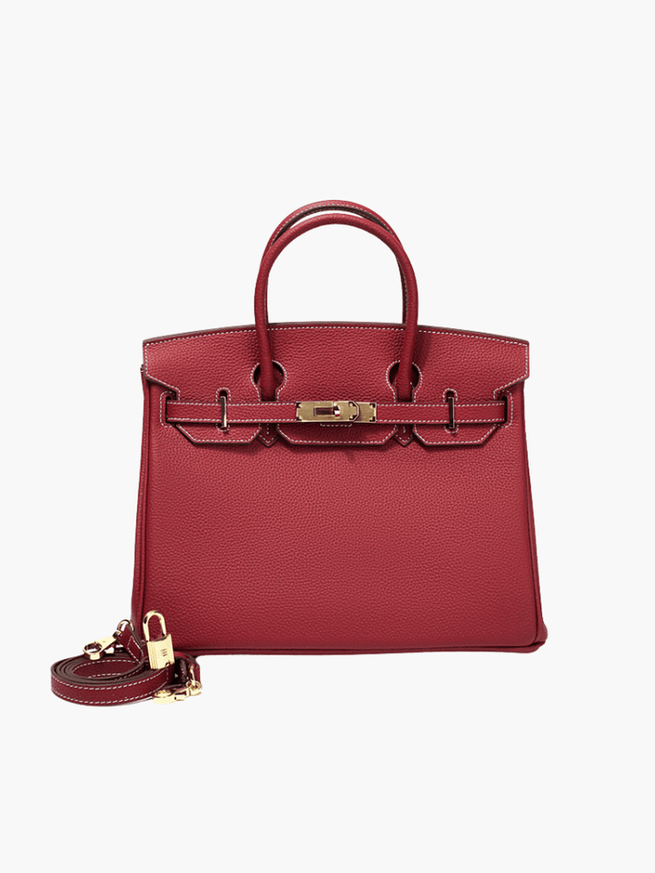 Red leather handbag with top handles, front flap, and gold-tone hardware with shoulder strap.
