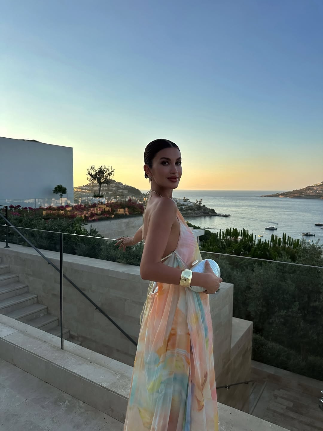 Orange printed halter maxi dress with spaghetti straps and draped floor-length skirt